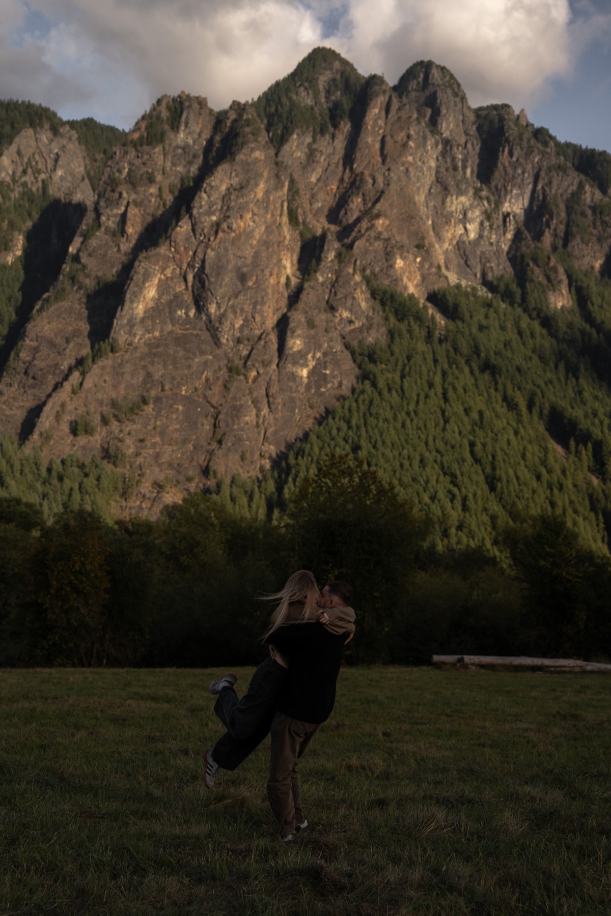 Newly engaged couple celebrating together beneath the mountains