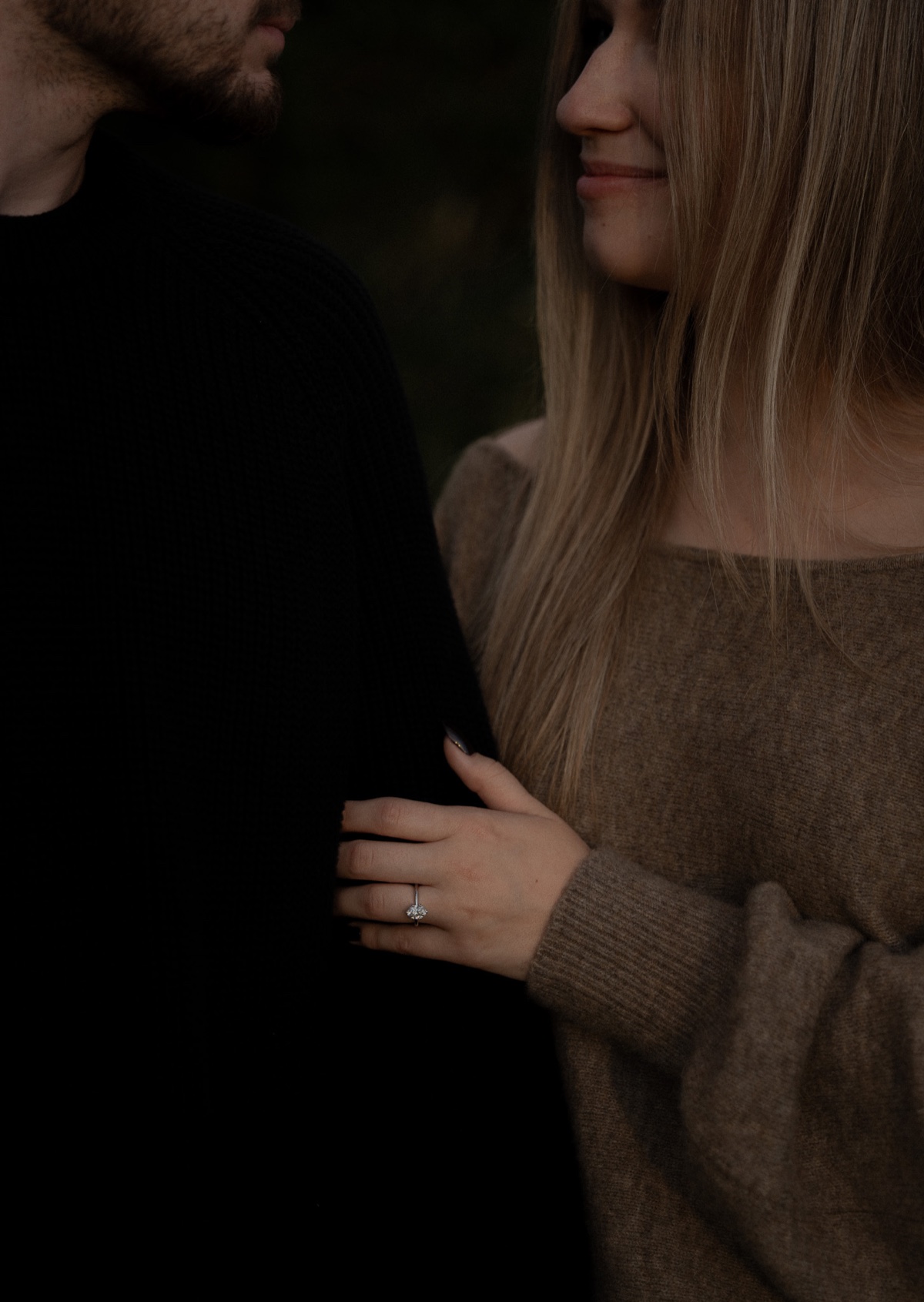Close engagement portrait showing the couple and an engagement ring