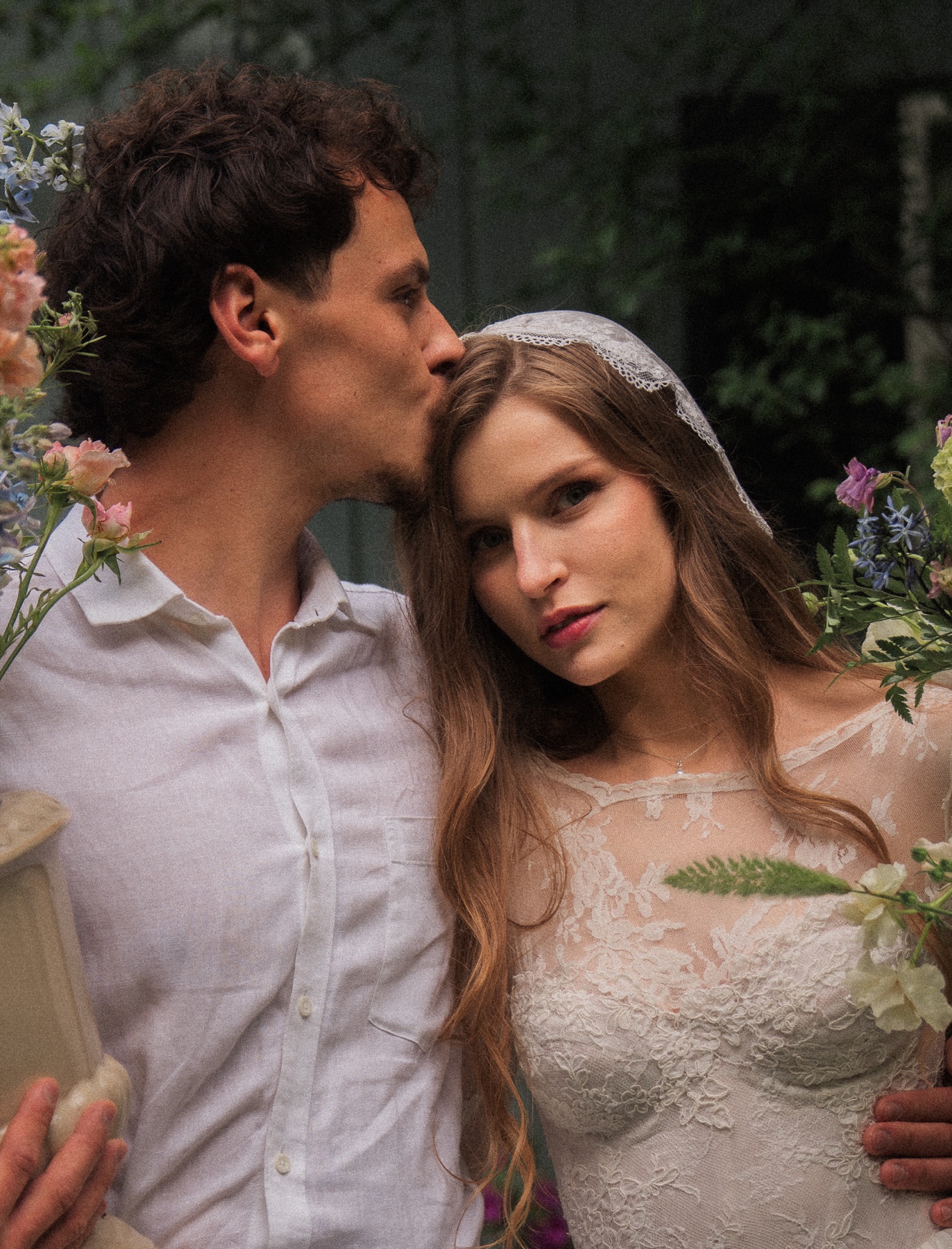 Wedding couple holding each other among white flowers